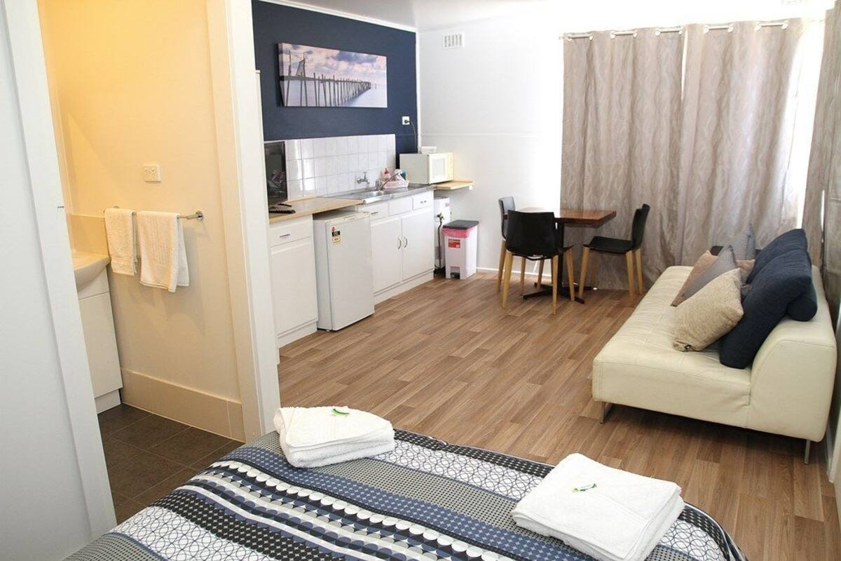 A compact living space with a kitchenette, a dining area, and a sofa.