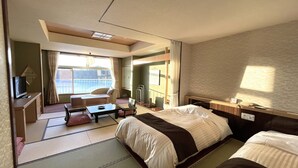 Una habitación de hotel con cama, escritorio, silla, mesita y televisión.
