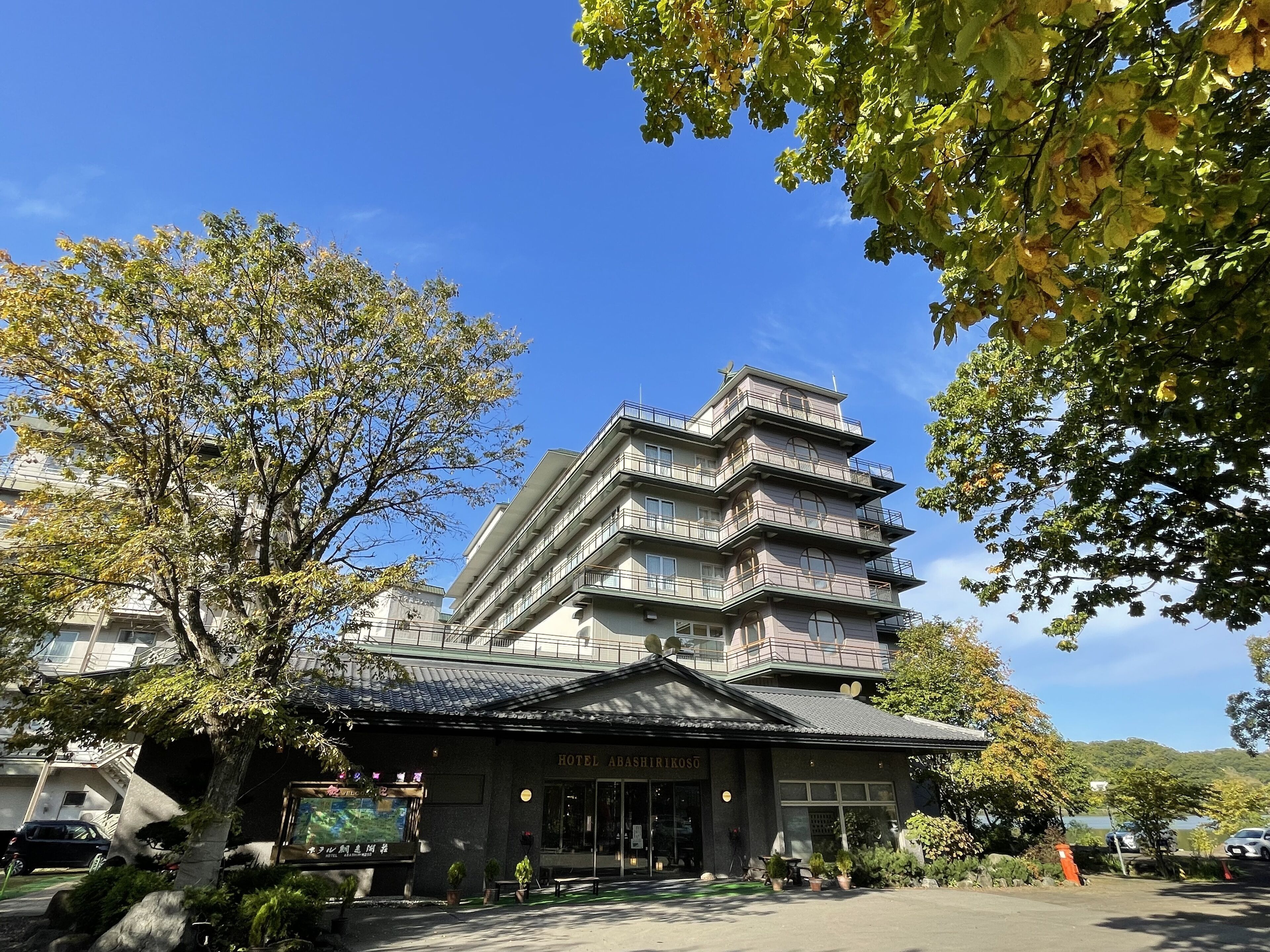 Un hotel de varios pisos con un diseño arquitectónico tradicional, con balcones y un letrero que dice "HOTEL ABASHIRIKOSU".
