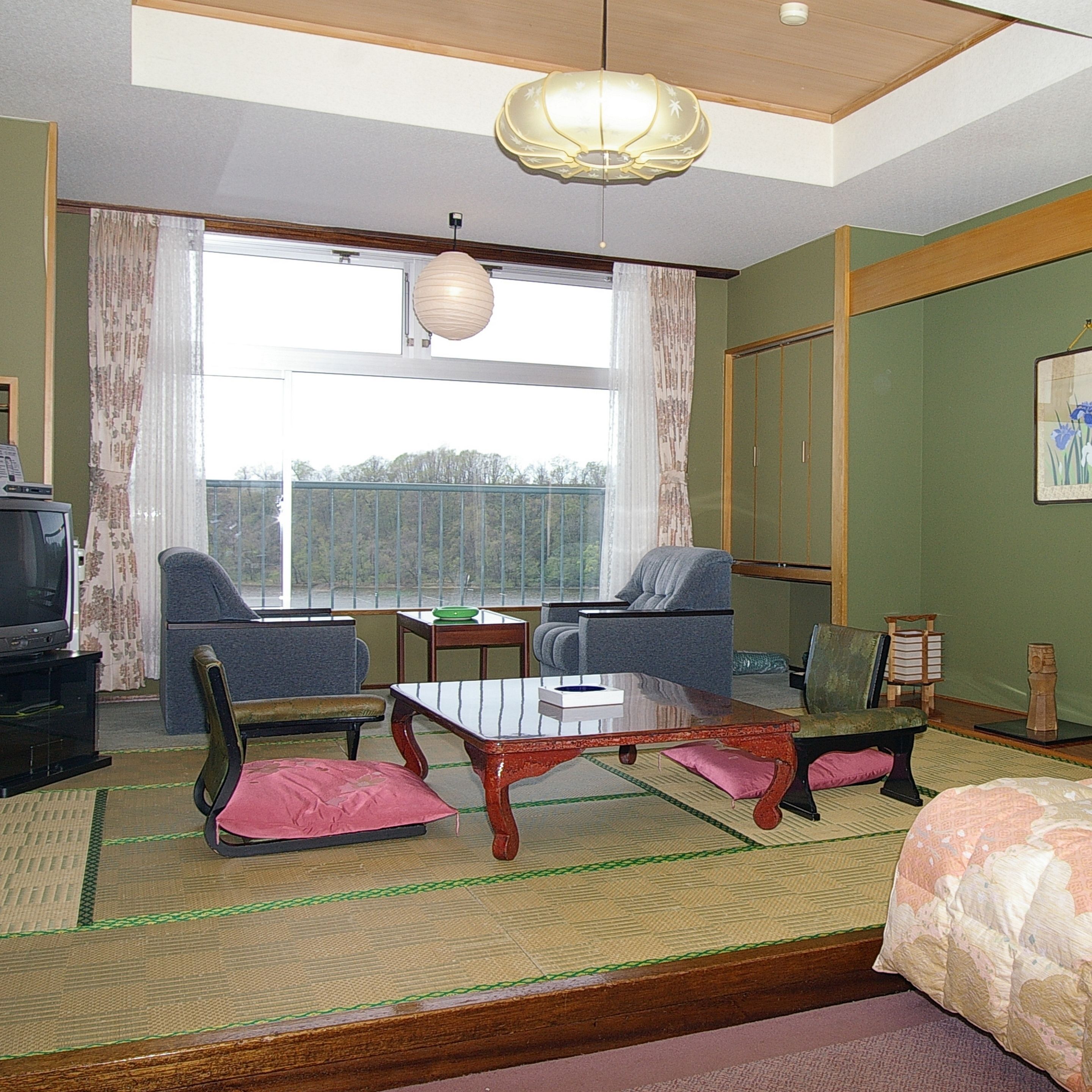 Una habitación con sofá, sillas, una mesa y televisor.