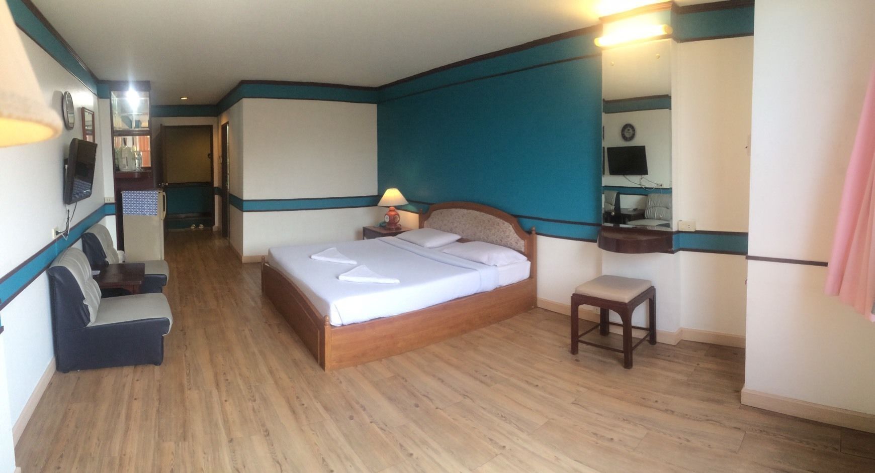Un dormitorio con cama, escritorio, silla y televisión.