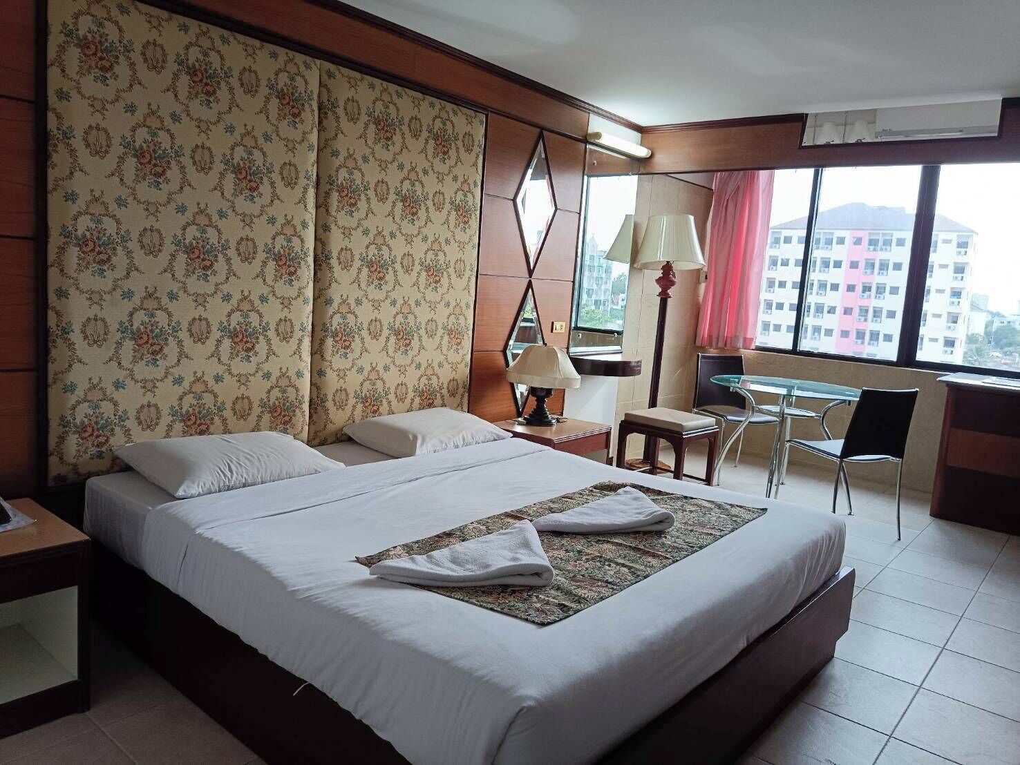 Una habitación de hotel con una cama grande, un escritorio y una silla.