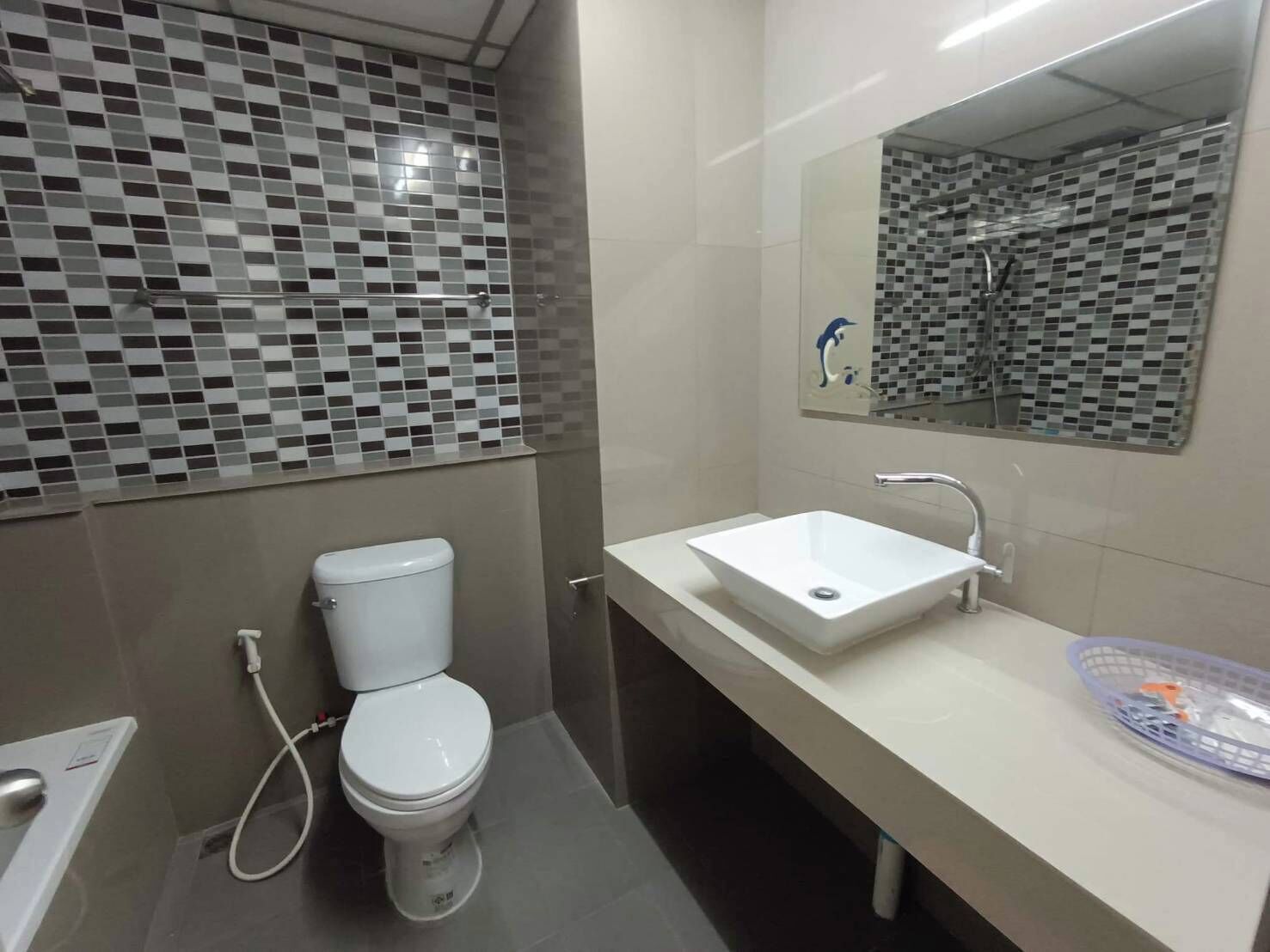 A modern bathroom with a white toilet, a white sink, and a shower area.