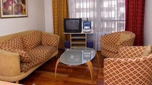 A living room with a sofa, a coffee table, a television, and a radio. - Complejo Recoleta (Mendoza)