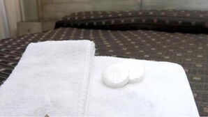 A hotel room with a neatly made bed, a white towel, and two white pillows on the bed. - Complejo Recoleta (Mendoza)