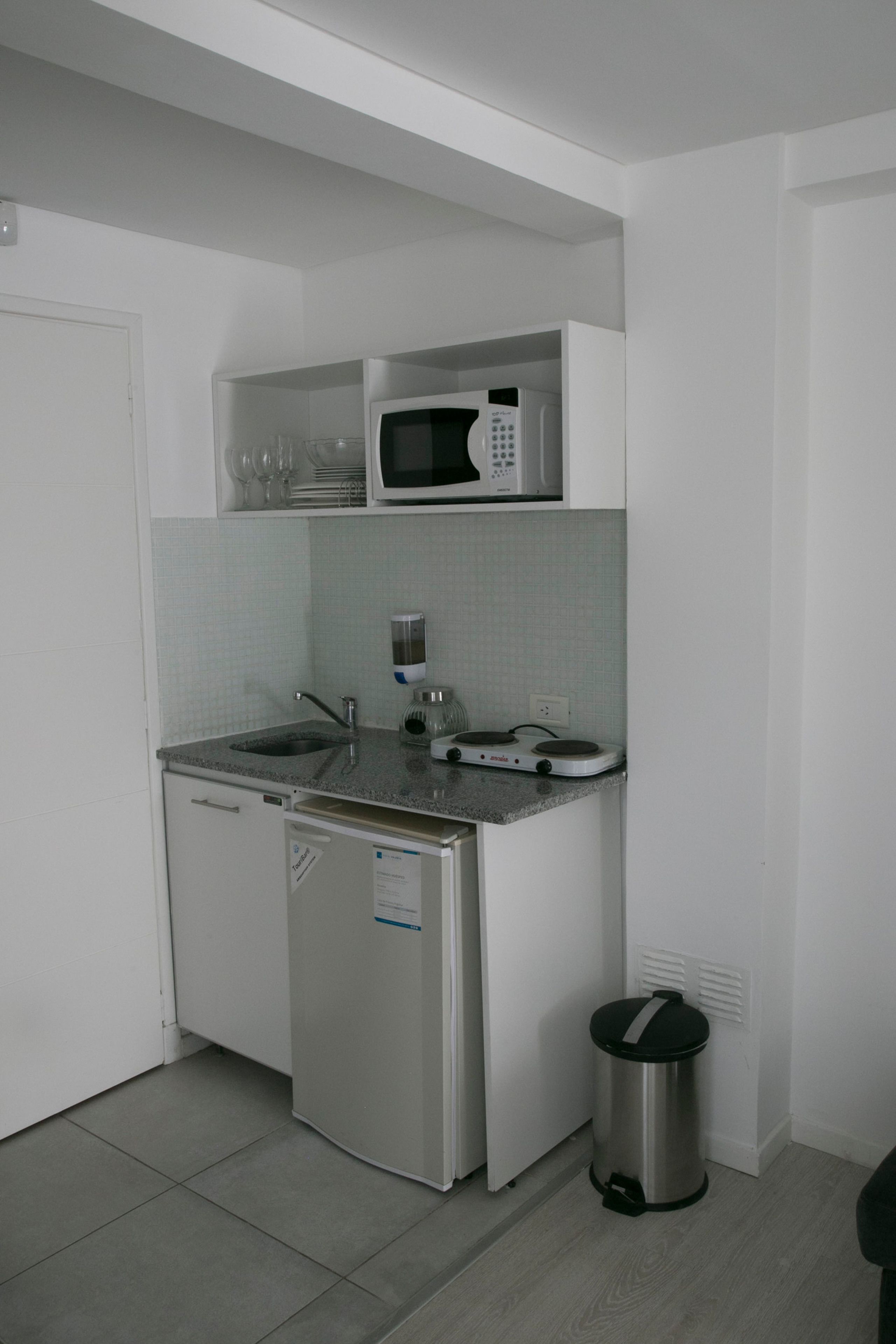 Cocina compacta con microondas, pileta y lavavajillas.