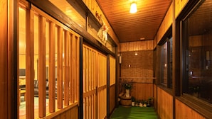 A narrow hallway with wooden walls and a green carpet. - Iyashinoyado Ryokan Tabataya (Myoko)