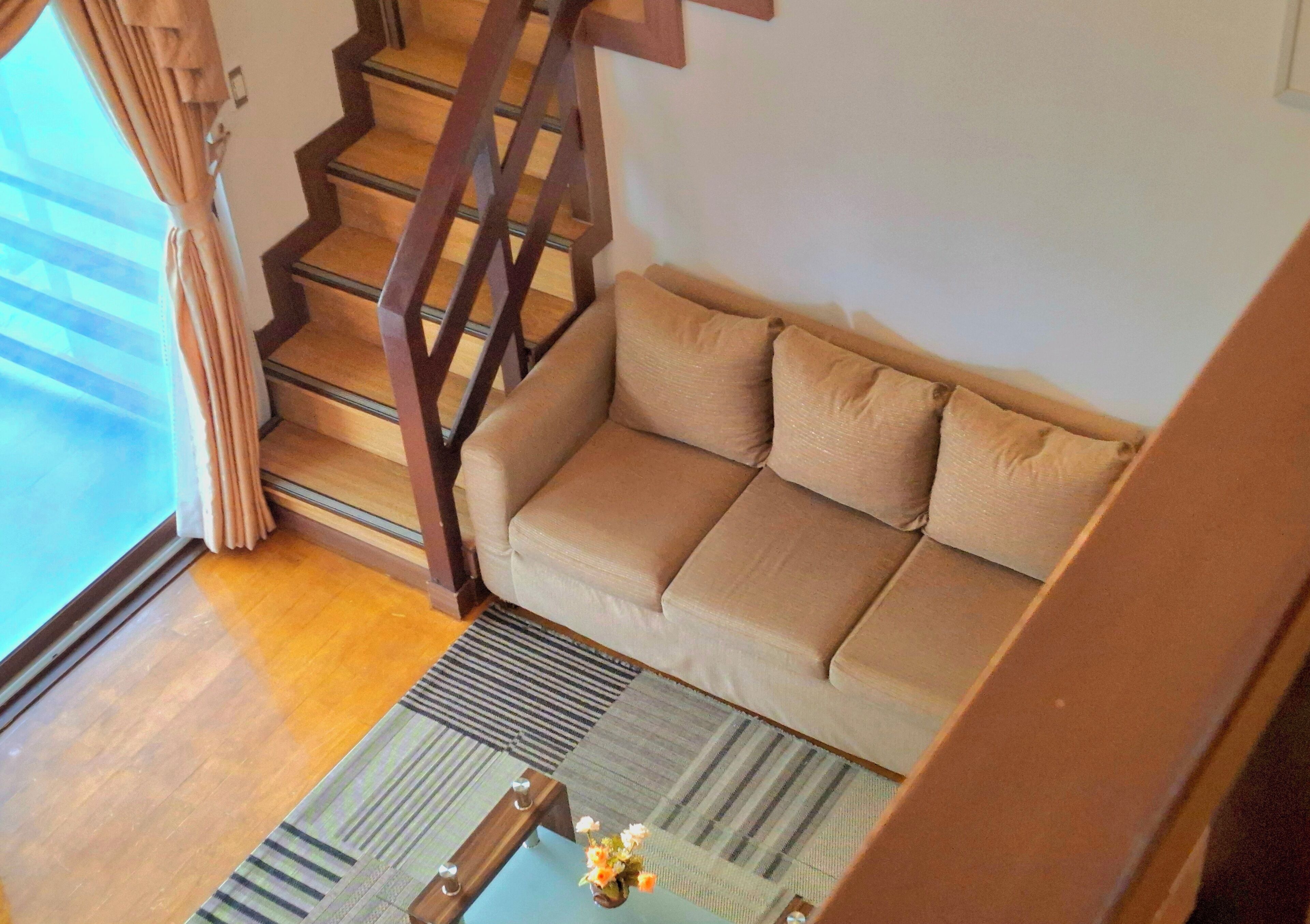 Un escalier menant à un espace de vie comprenant un canapé et une table basse.