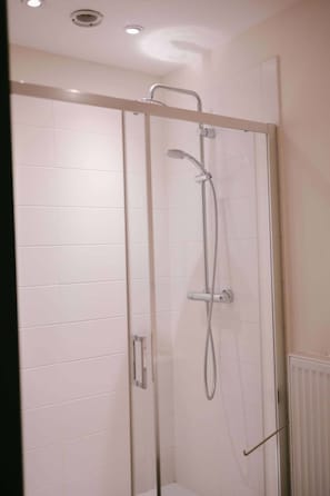 A glass-enclosed shower with a handheld showerhead and a wall-mounted faucet. - Le Val d'Arimont Hotel (Malmedy)