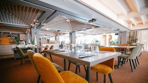 Un comedor moderno con una mesa larga, varias sillas y un techo con un diseño geométrico.