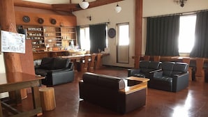 Un vaste espace de vie doté d’un plancher en bois, d’un mur en briques avec des étagères et d’un coin bar portant l’inscription « NOTRACK ».