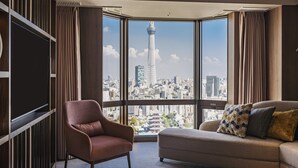Una habitación moderna con un amplio ventanal que ofrece vistas a la ciudad, incluyendo una torre destacada.