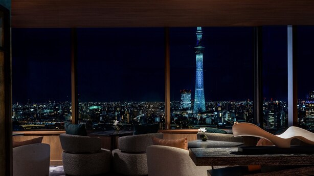 Un interior moderno con vistas a la ciudad, destacando una torre imponente.
