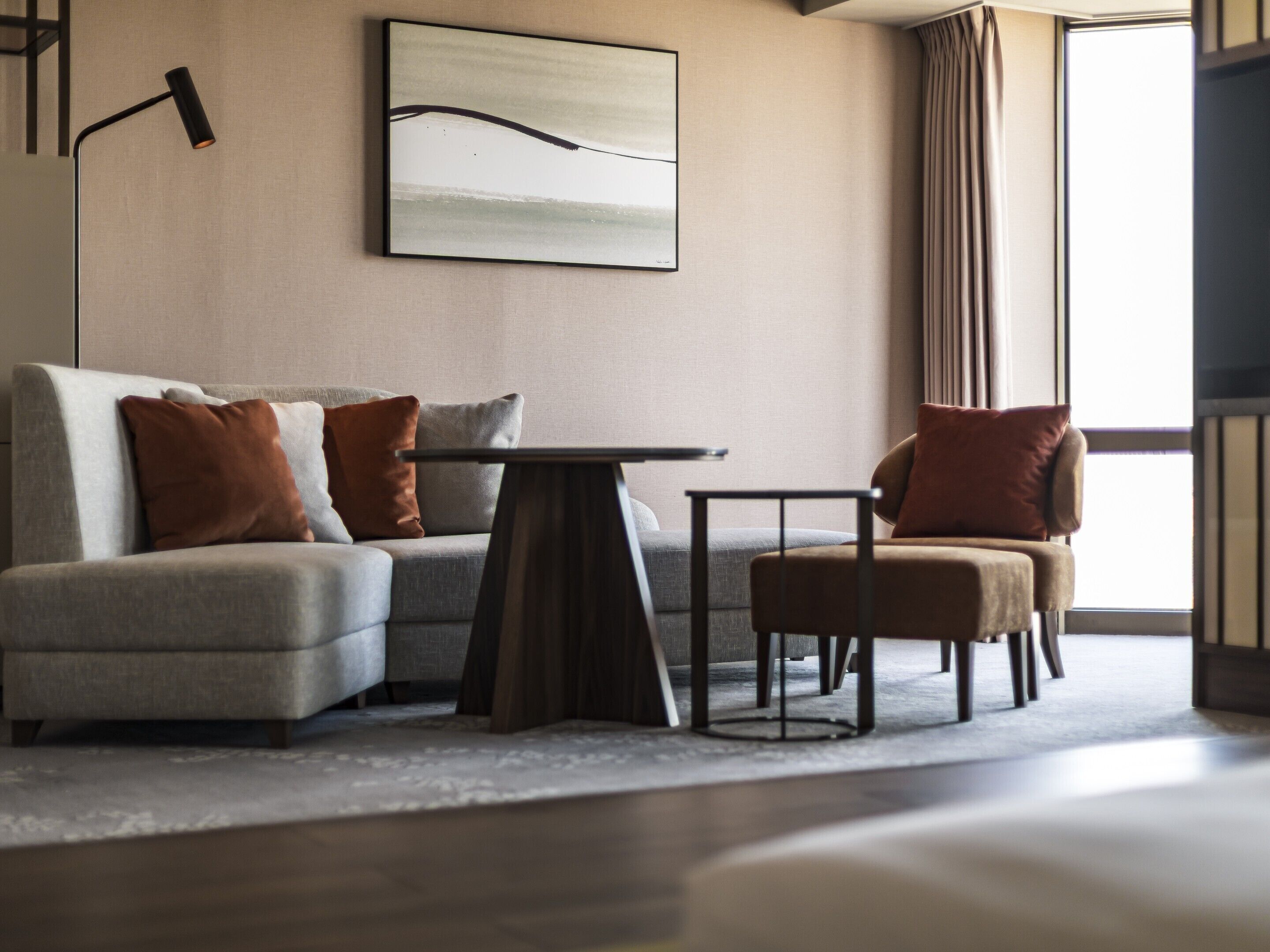 A modern living room with a sofa, a small table, and a chair.