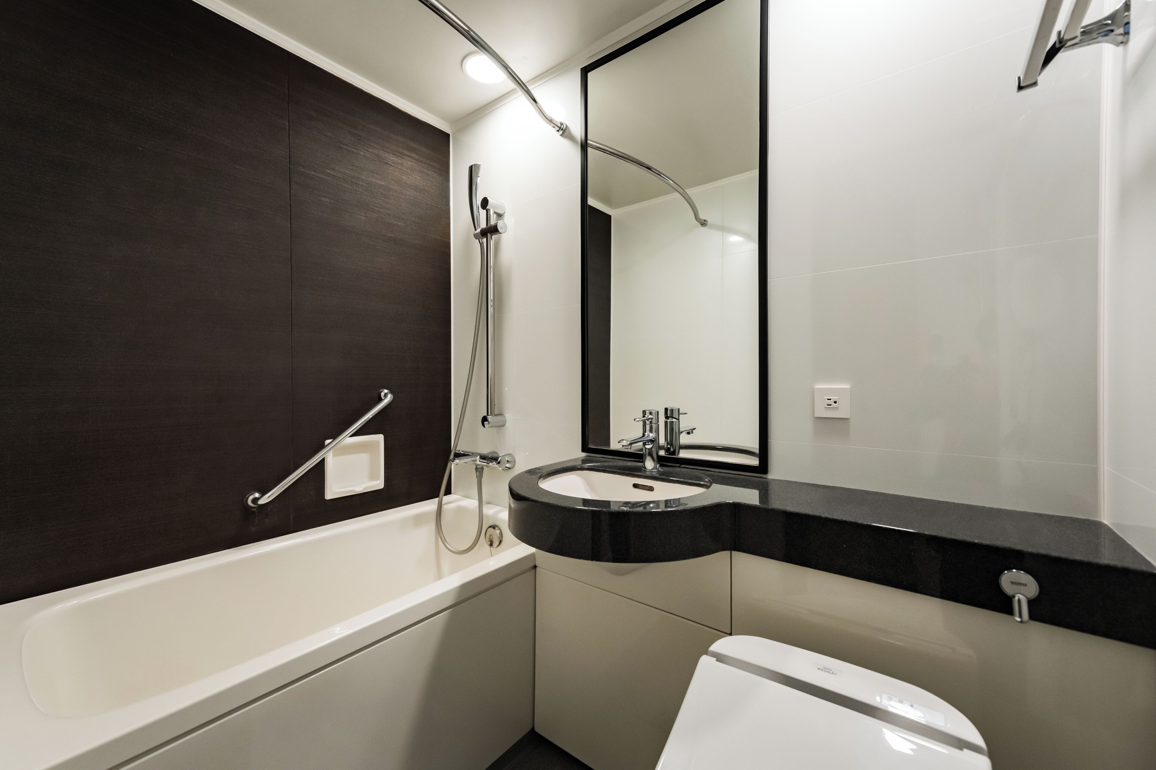 A modern bathroom with a bathtub, a sink, and a toilet.