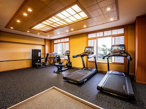 A gym with treadmills, elliptical machines, and weight equipment.