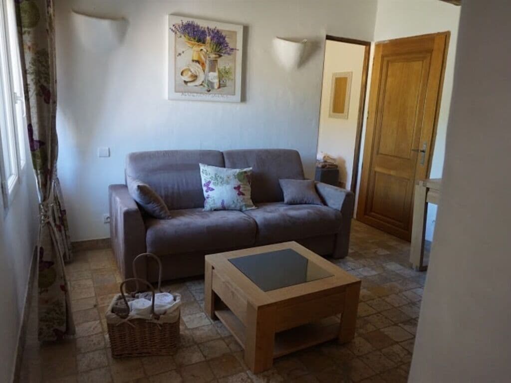A living room with a grey sofa, a wooden coffee table, and a wicker basket.