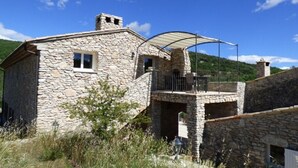 A stone building with a balcony and a covered outdoor area. - La Buisse (Simiane-la-Rotonde)