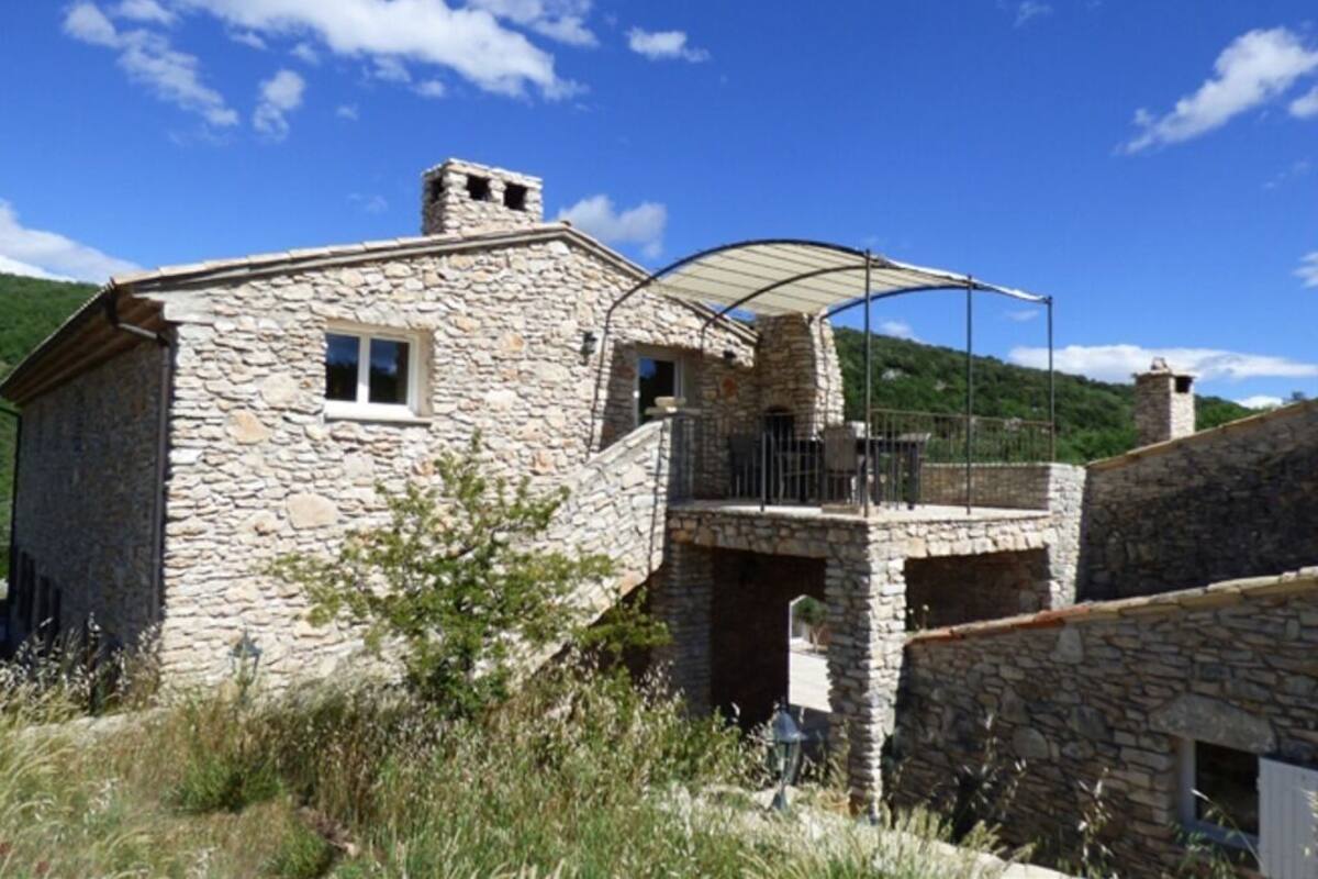 A stone building with a balcony and a covered outdoor area.