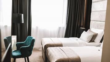 Camera d'albergo con due letti, una scrivania e una sedia.