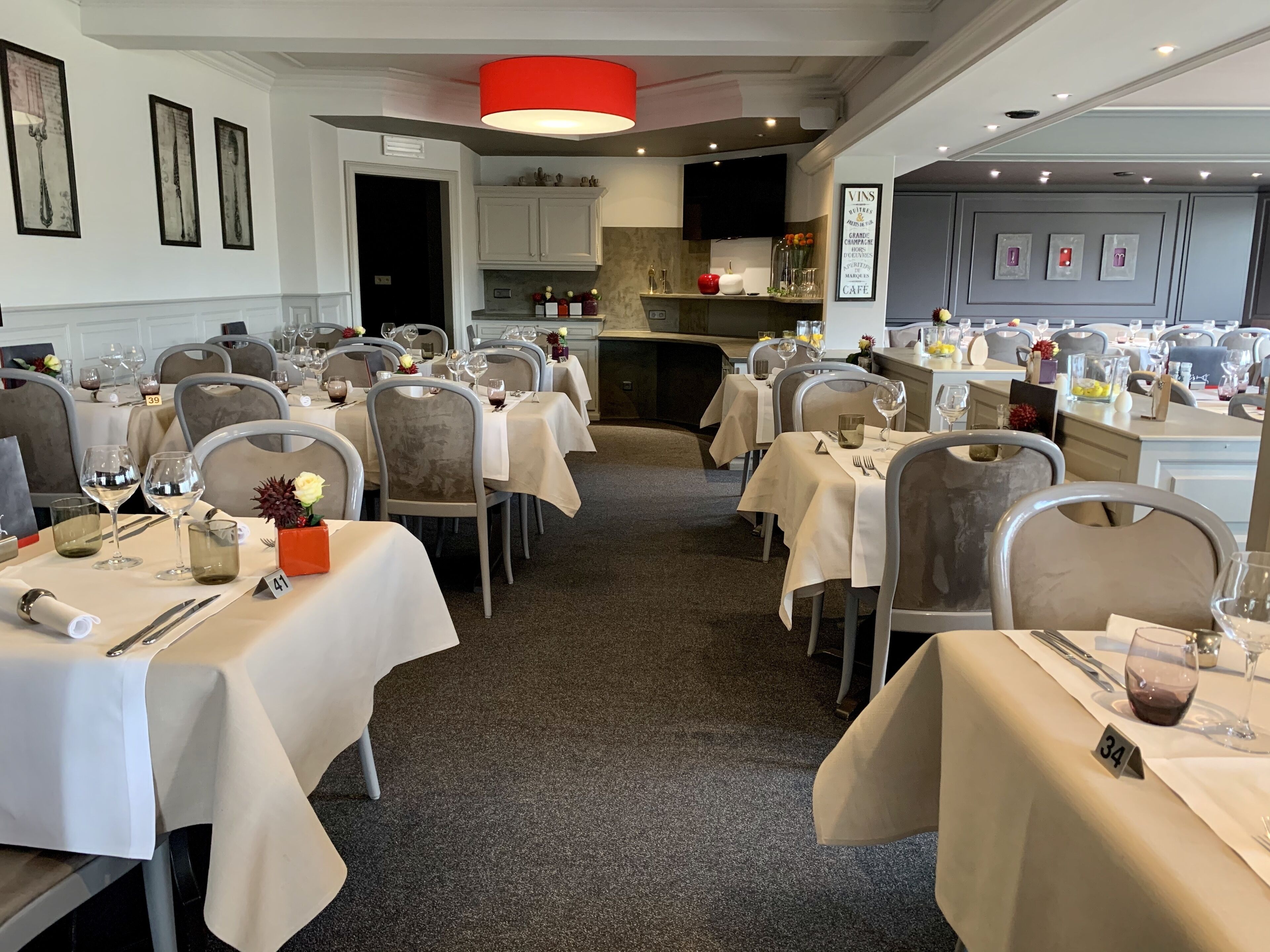 A restaurant with multiple tables set for dining, each with chairs and table settings.