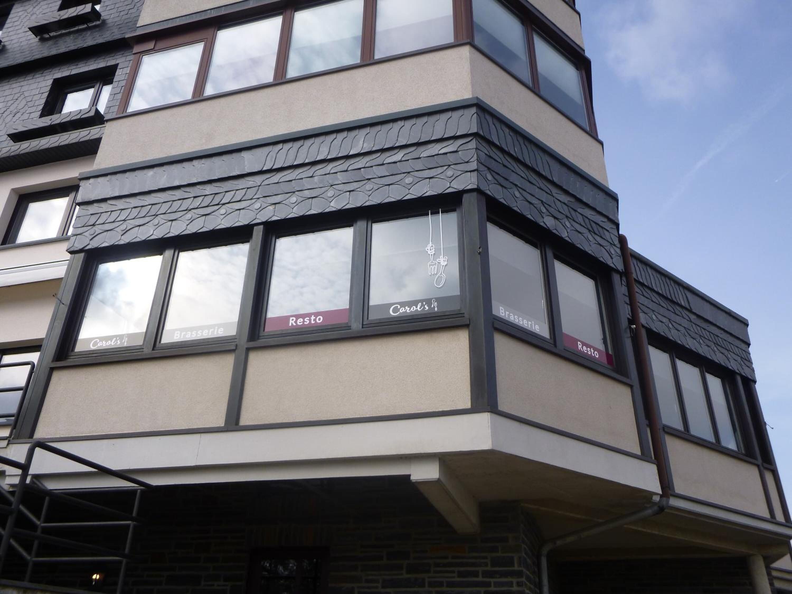 Un edificio con varias ventanas que exhiben los nombres 