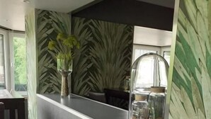 Una cocina moderna con encimera gris, una silla de madera y una planta en maceta.