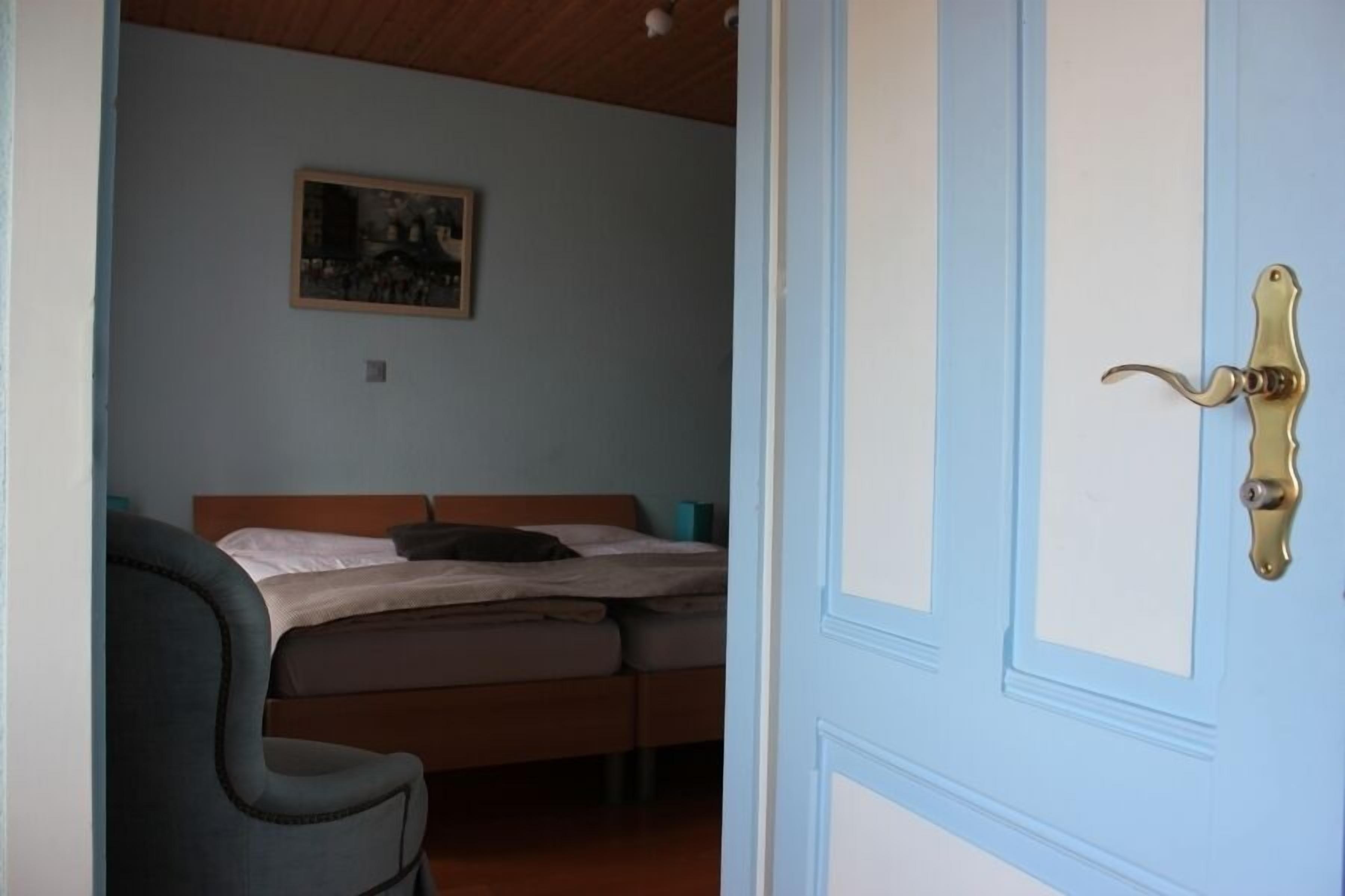 Une chambre à coucher avec un lit, une chaise et une porte.