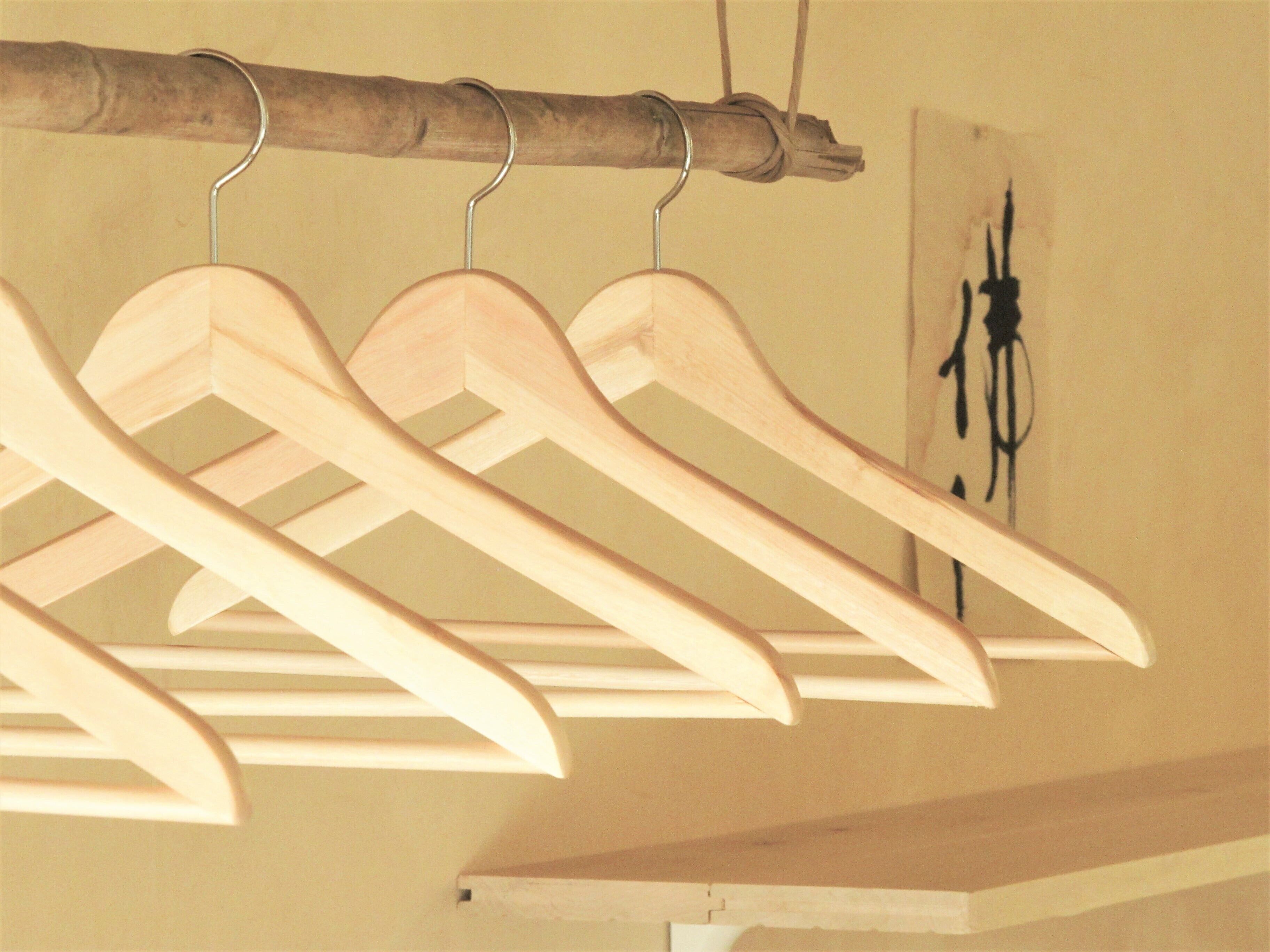 A wooden clothing rack with several hangers.