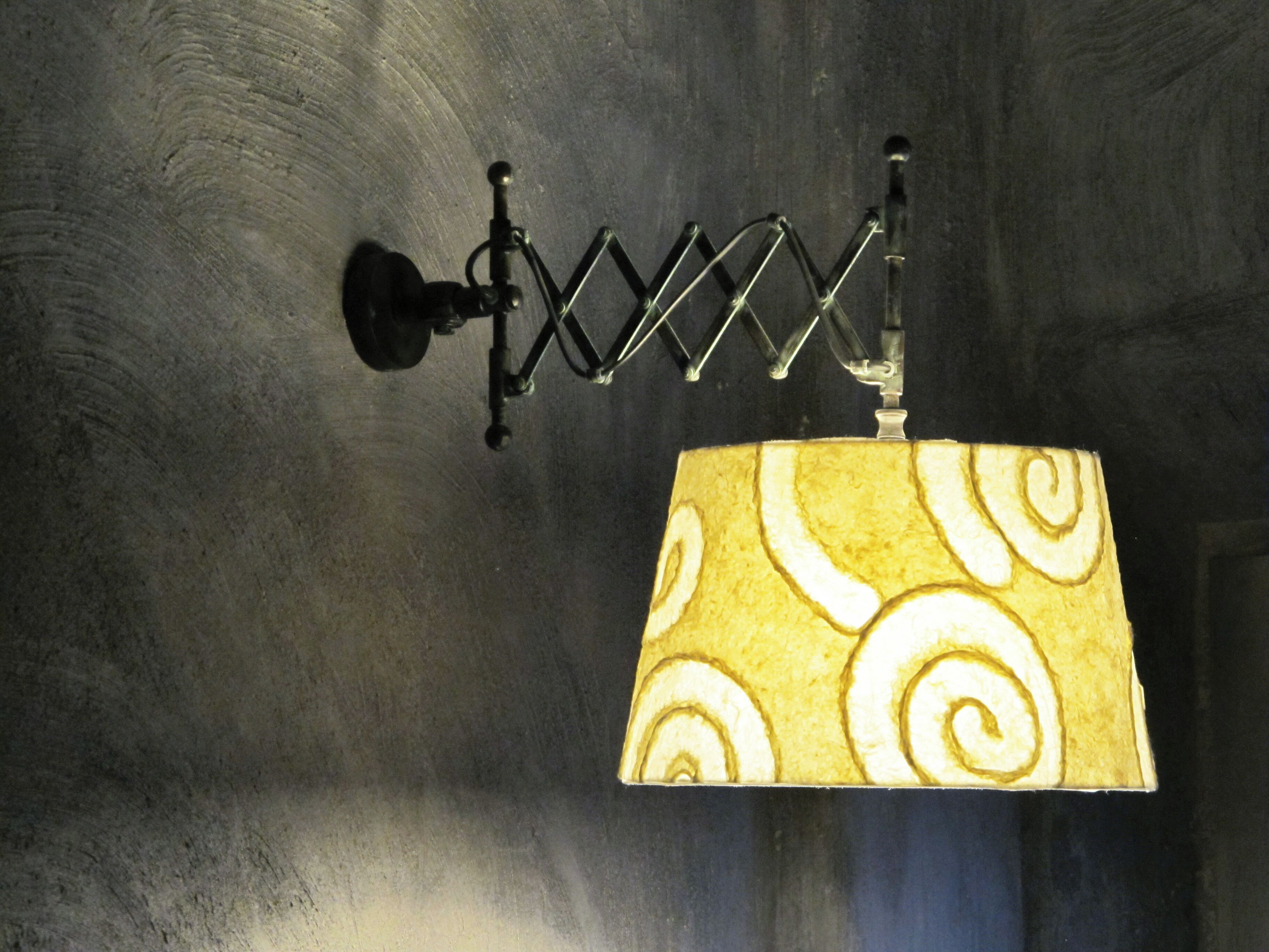 A wall-mounted lamp with a spiral-patterned lampshade.