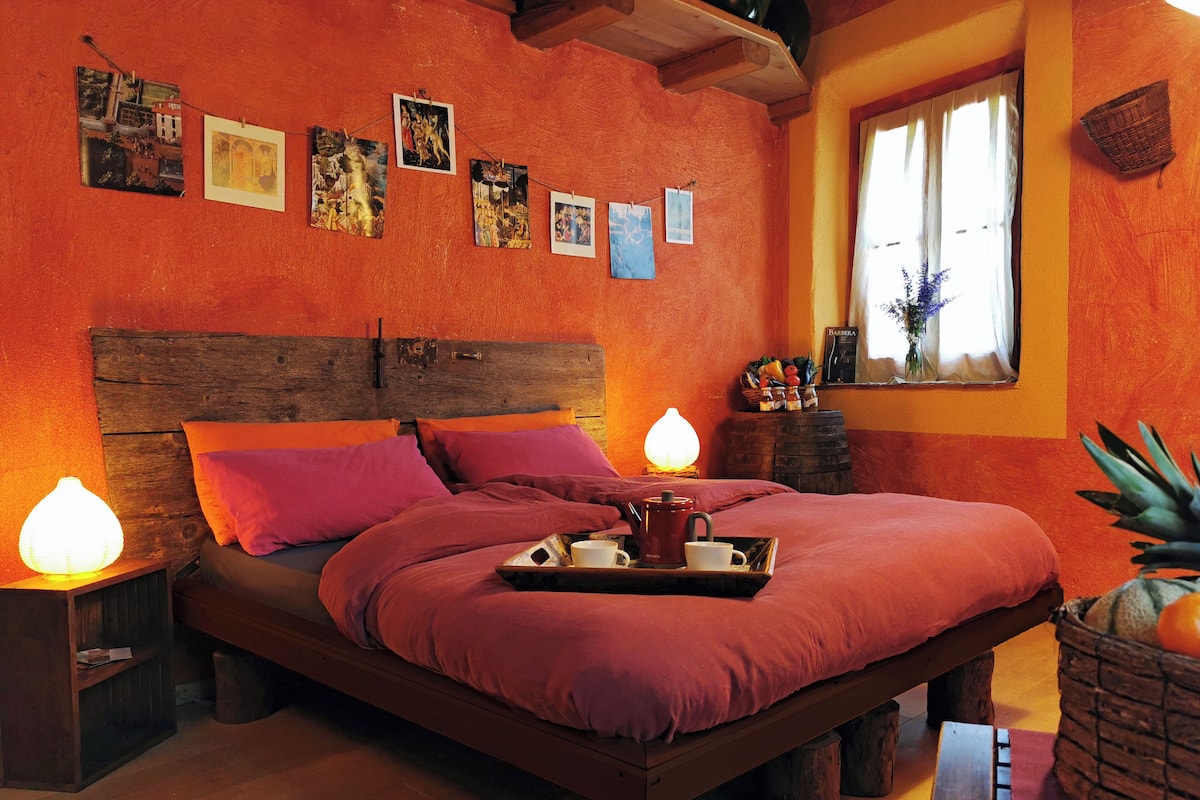 A cozy bedroom with a wooden bed frame, a wooden headboard, and a wooden nightstand with a lamp.