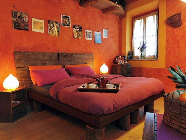 Un dormitorio acogedor con estructura de cama y cabecera de madera, además de una mesita de noche con lámpara.