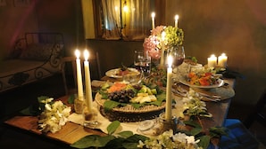 A dining table set with candles, plates of food, and a vase of flowers. - Galbusera Bianca  (La Valletta Brianza)
