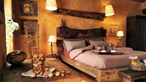 A rustic bedroom with a wooden bed, two bedside tables with lamps, a wooden nightstand, and a wooden bench. - Galbusera Bianca  (La Valletta Brianza)