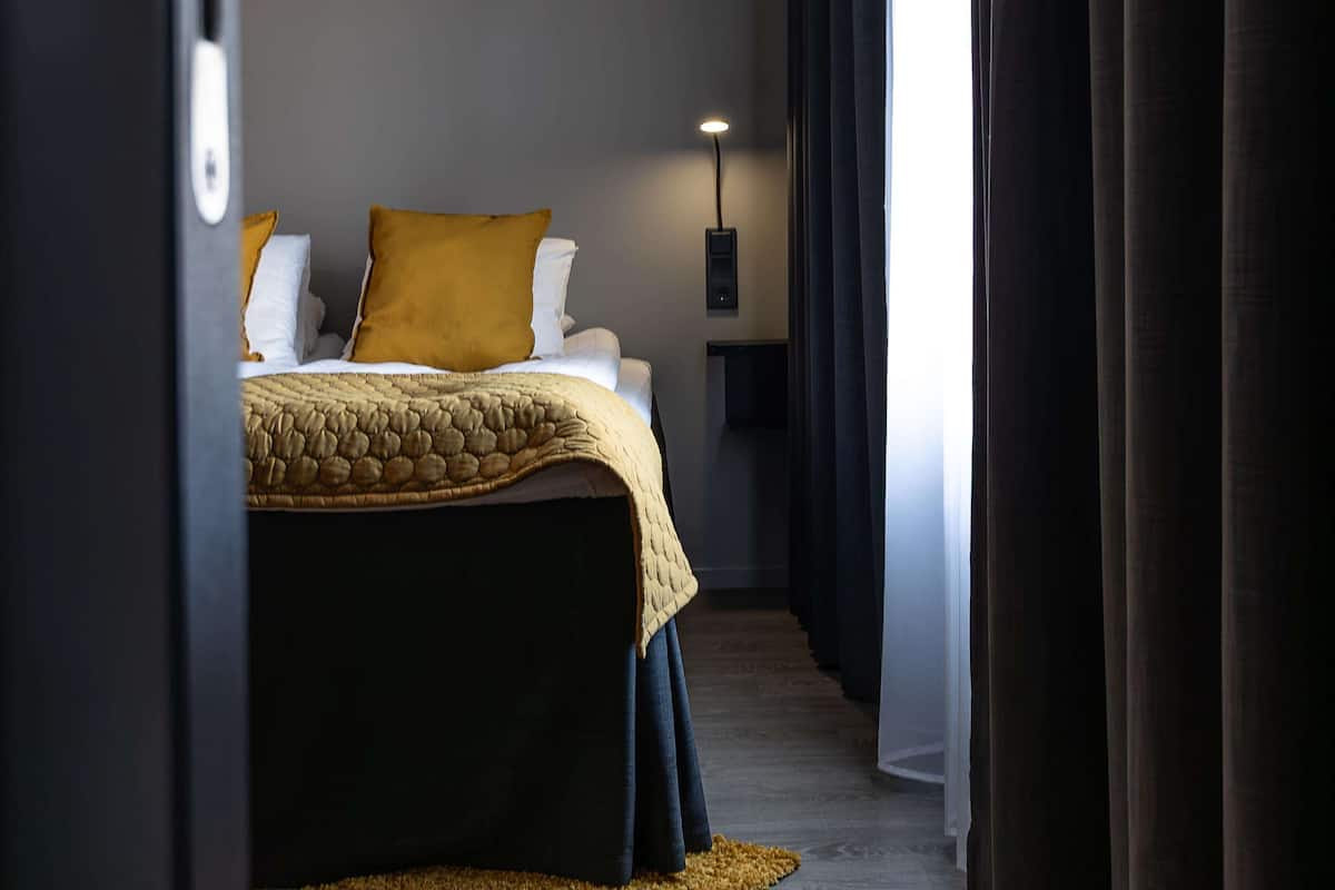 Ein Hotelzimmer mit einem Bett, einem Nachttisch und einer Lampe.