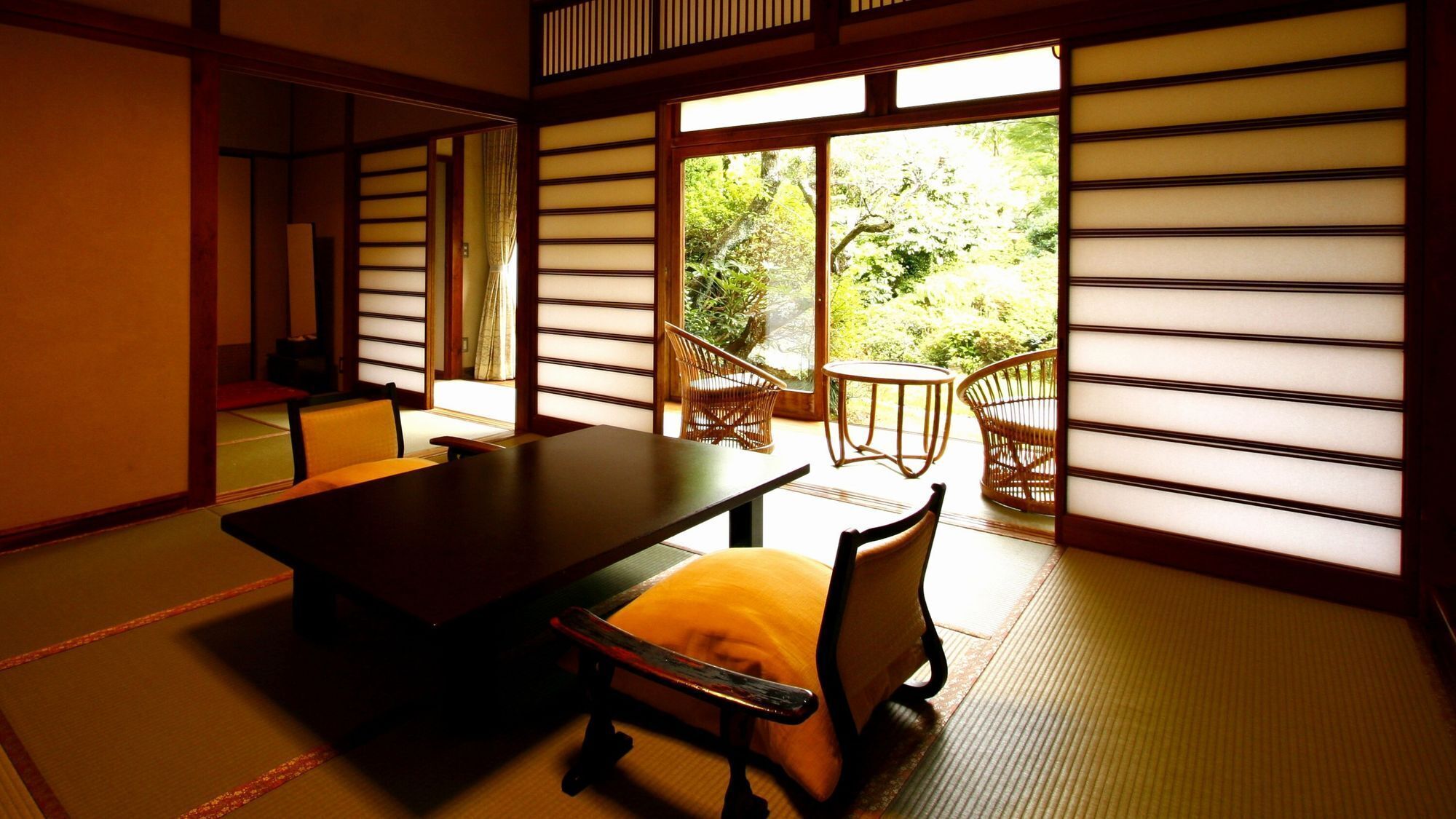 A traditional Japanese room with tatami flooring, a low table, and a sofa.