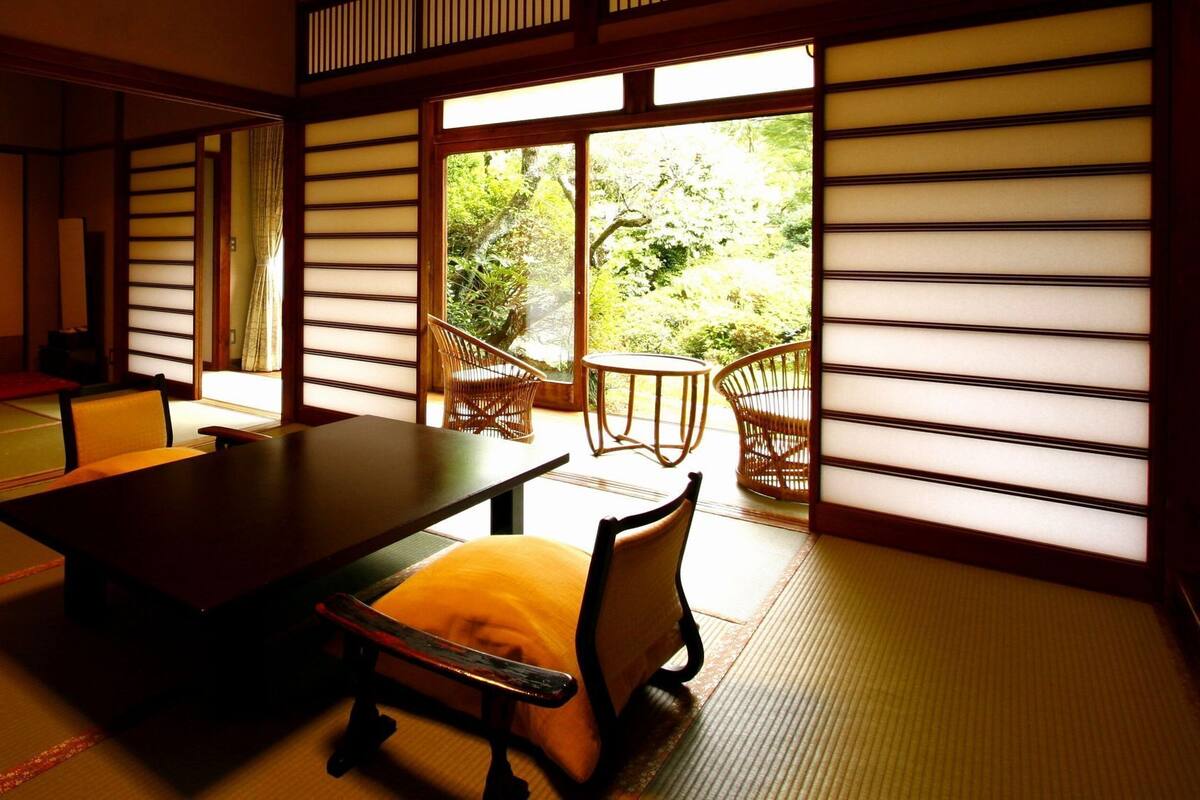 A traditional Japanese room with tatami flooring, a low table, and a sofa.