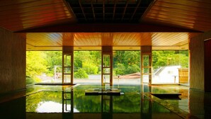 A spacious indoor area with large windows, a reflective floor, and a view of greenery outside. - Gensenkakenagashi No Yu Onyado Sakaya (Shizuoka)