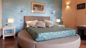 Ein Schlafzimmer mit einem großen Bett, zwei Nachttischen, einem Wandbild und einer Wandleuchte.