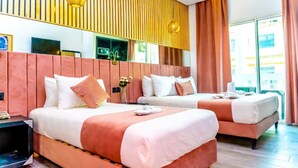 A hotel room with two beds, a wooden slatted headboard, a large mirror, and a view of the city. - Hotel Les Ambassadeurs (Casablanca)