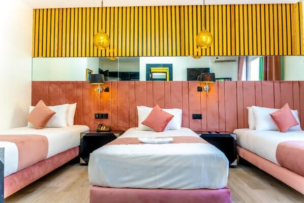 A hotel room with two beds, a large mirror, and a wooden headboard.