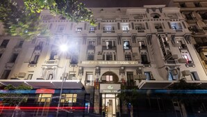 Un hotel elegante con fachada clásica, varios balcones y una entrada imponente.