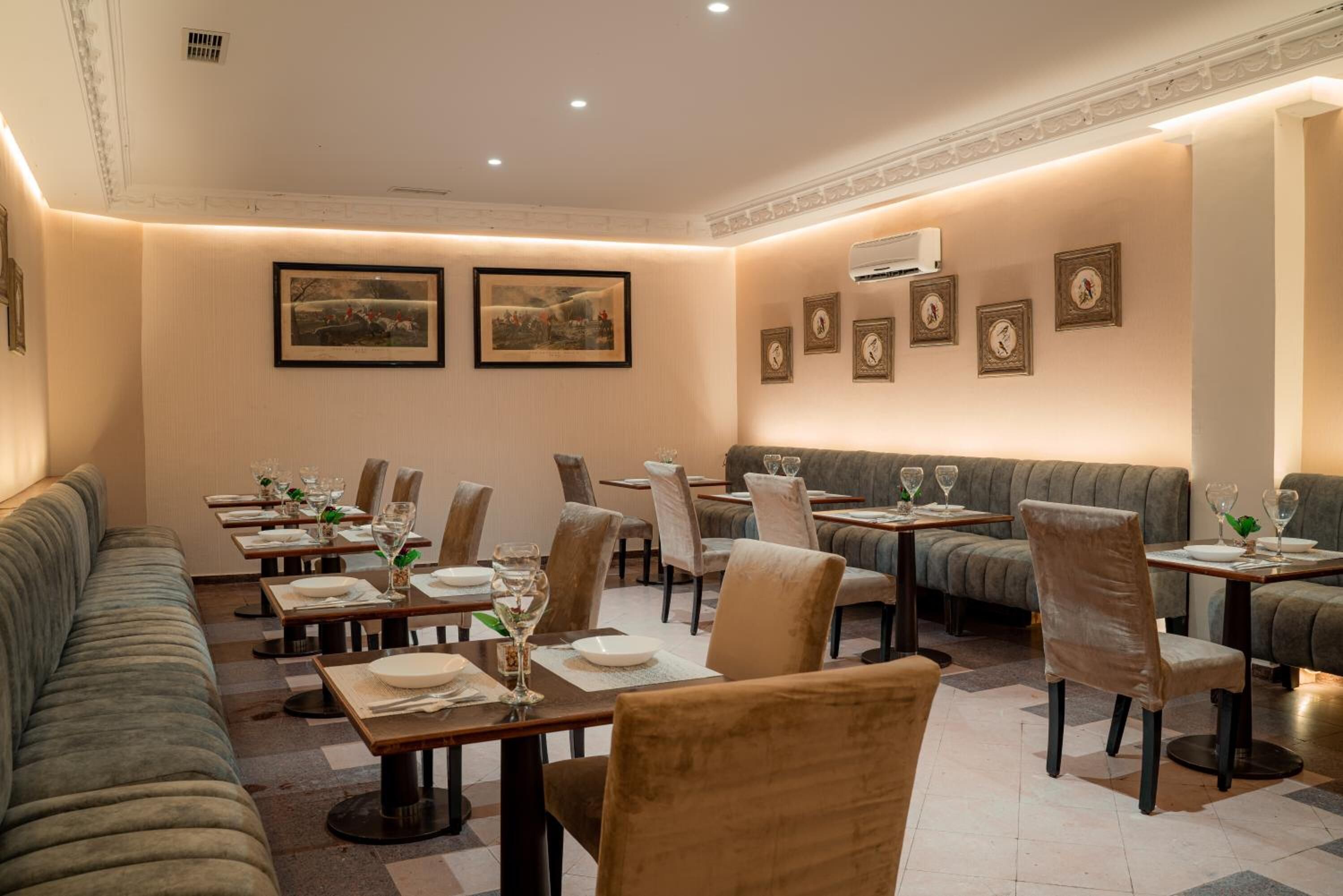 Un restaurante con una barra alargada, cabinas y un techo alto con iluminación empotrada.