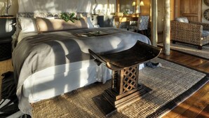 A bedroom with a bed, bedside table, and a chair.