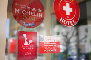 A close-up of various signs, including a Michelin guide selection sign, a passport gourmet partner sign, and a hotel sign. - Auberge Aux Deux Sapins (Montricher)
