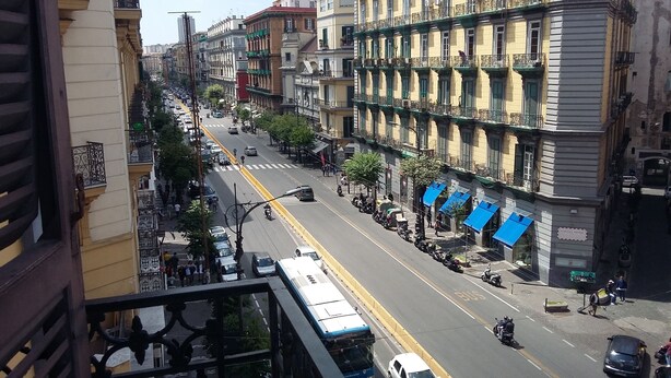 Vista de una calle con edificios, un paso de peatones y un autobús.
