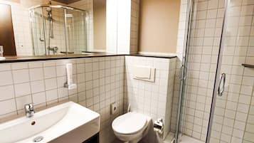 A modern bathroom with a sink, toilet, and glass-enclosed shower.