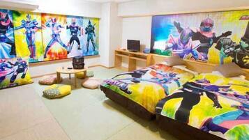 A bedroom with a large bed, a desk, and a TV.