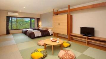 A modern hotel room with a bed, a TV, a wooden wardrobe, and tatami mats.
