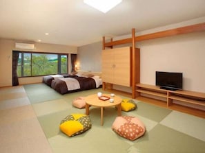 Une chambre d’hôtel moderne équipée d’un lit, d’une télévision, d’une armoire en bois et de tatamis.